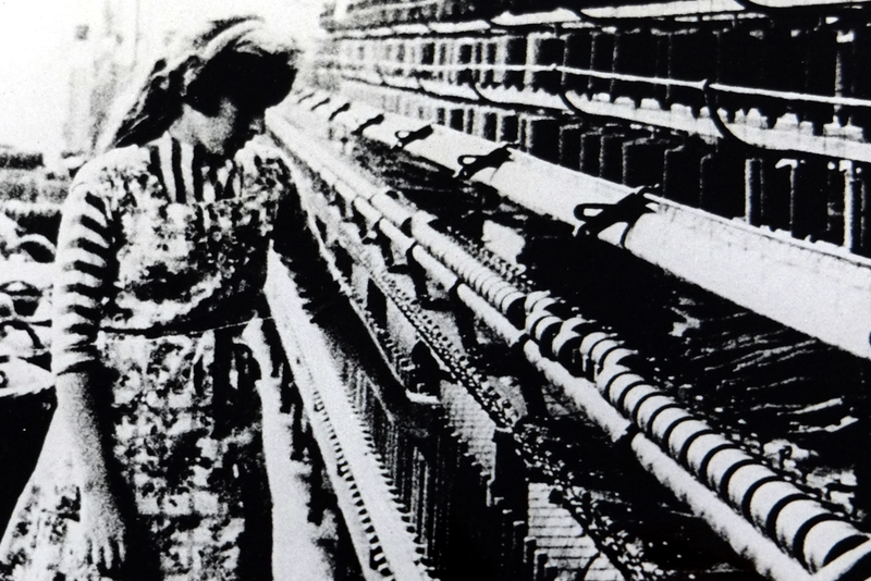 Mitarbeiterin der Textilfabrik Irmen am Webstuhl 