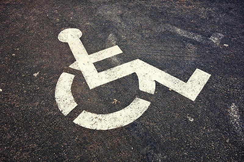 Symbol Rollstuhl auf Asphalt