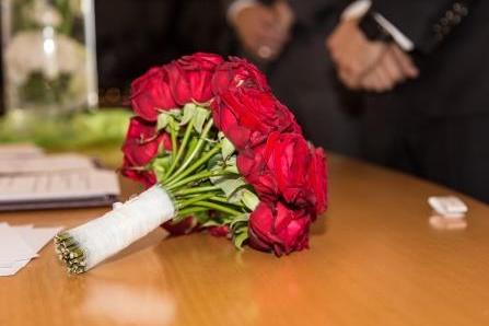 Brautstrauß aus Rosen liegt auf einem Tisch.